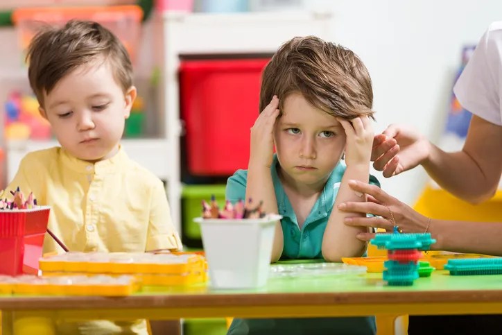 Angry little boy in classroom.